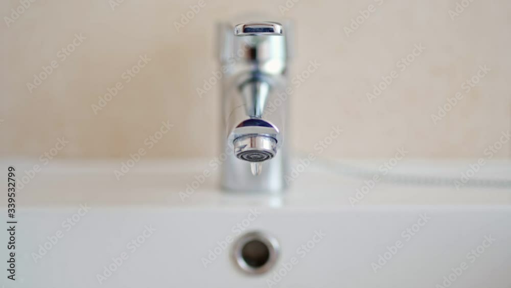 Frontal shot off dripping tap at bathroom Frontal shot off dripping tap at bathroom