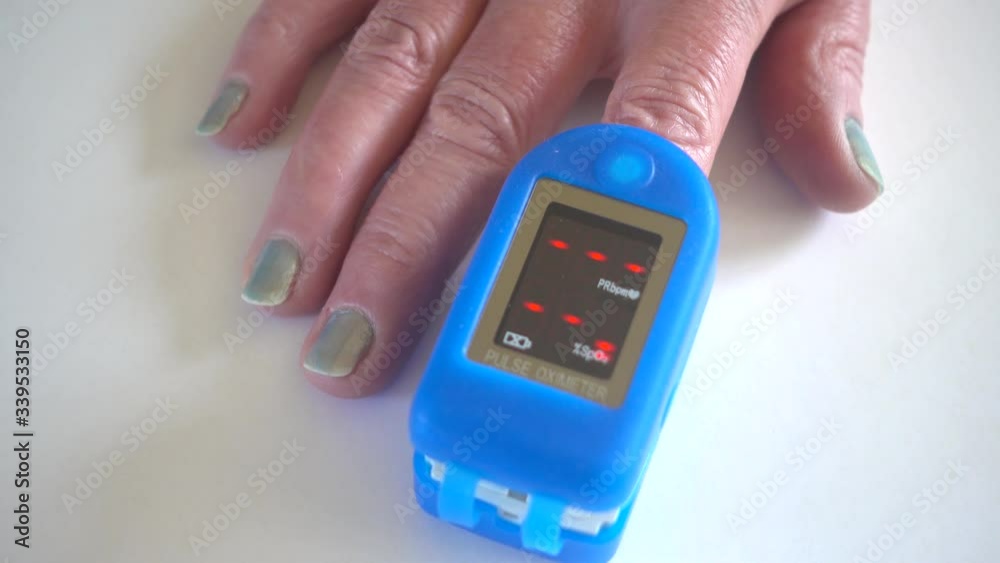 Pulse oximeter on finger being used to test blood oxygen level in case of virus infection of the lungs Pulse oximeter on finger being used to test blood oxygen level in case of virus infection of the lungs