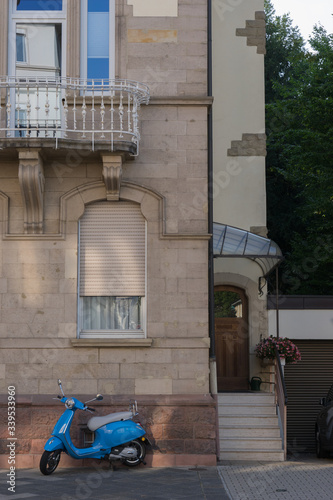 Motorroller vor dem alten Gründerzeithaus mit Rundbogenfenstern © tina7si