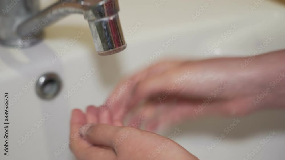The child carefully washed his hands with soap close up The child carefully washed his hands with soap close up