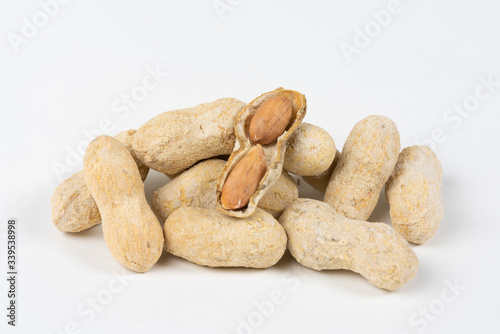 Shelled salted peanuts in shell on white background