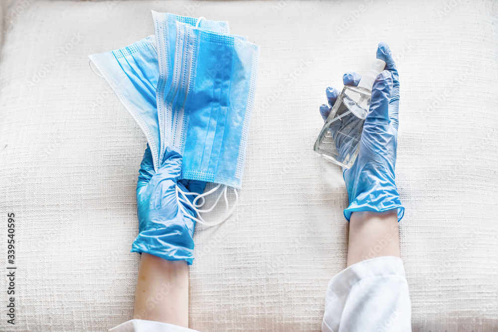 A hands in gloves taking for coronavirus prevention medical masks and sanitizer spray for hand hygiene corona virus protection.Concept of healthy life and prevention corona virus.