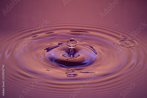 Splash of water crown on red surface