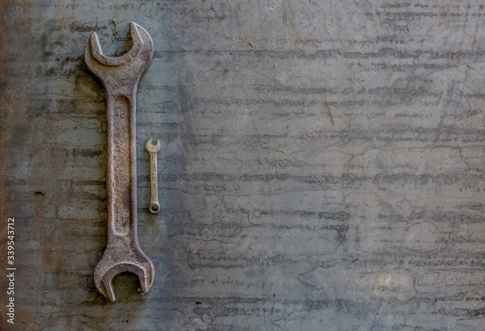 Old rusty wrench on a white and metal background. several wrenches of different sizes. Card with copy space for text Old rusty wrench on a white and metal background. several wrenches of different sizes. Card with copy space for text