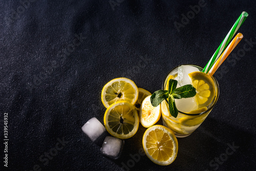 Fresh bright summer cocktail. Mojito cocktail with lime, lemon and mint in a glass on a fashionable stone background. Lemon mojito