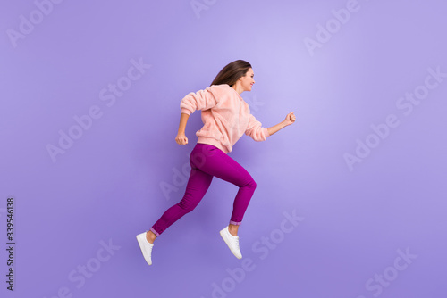 Fototapeta Naklejka Na Ścianę i Meble -  Full length profile photo of active lady jumping high up rushing speed shopping sale black friday wear casual warm fluffy sweater pants shoes isolated purple color background