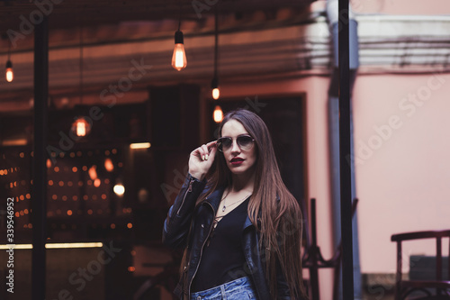 Good looking woman in leather jacket walking in city