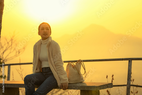 Wallpaper Mural tourist women in white shirt and jeanes sit bench in relaxing Emotional The winter with blur background mountain sunrise in the morning at Phutok hill view point, Chiangkhan, Loei Province, Thailand. Torontodigital.ca