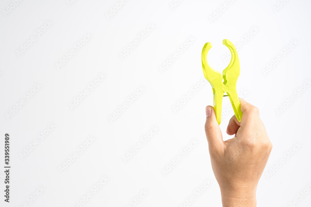Hand holding large plastic spring clamp for paper Hand holding large plastic spring clamp for paper