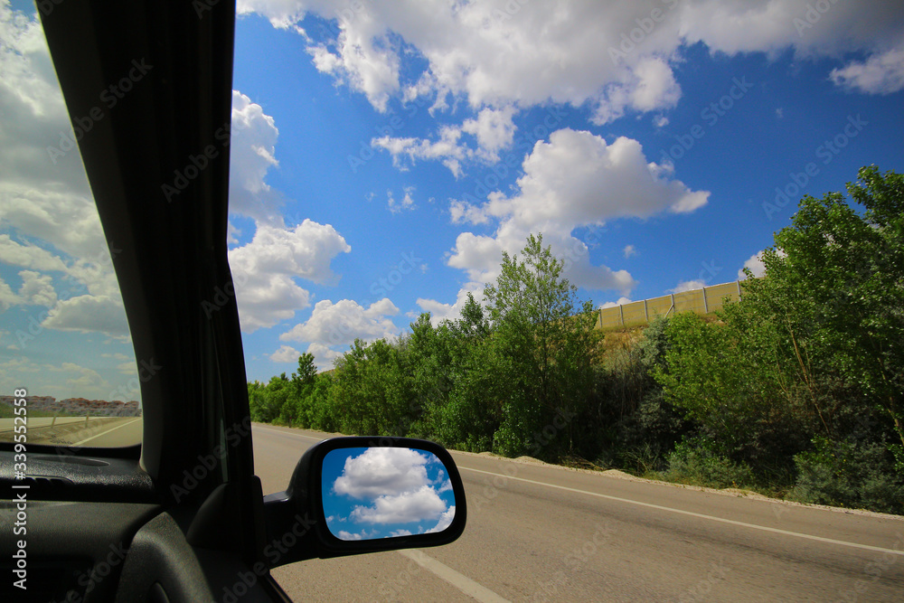 Asphalt road and cloudy blue sky from vehicle window. It was also taken during the journey in a sunny day. Turkey