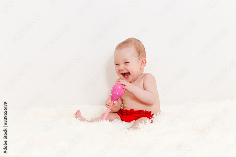 cute Caucasian baby girl in red panties sits on the bed and laughs. baby barefoot cute Caucasian baby girl in red panties sits on the bed and laughs. baby barefoot