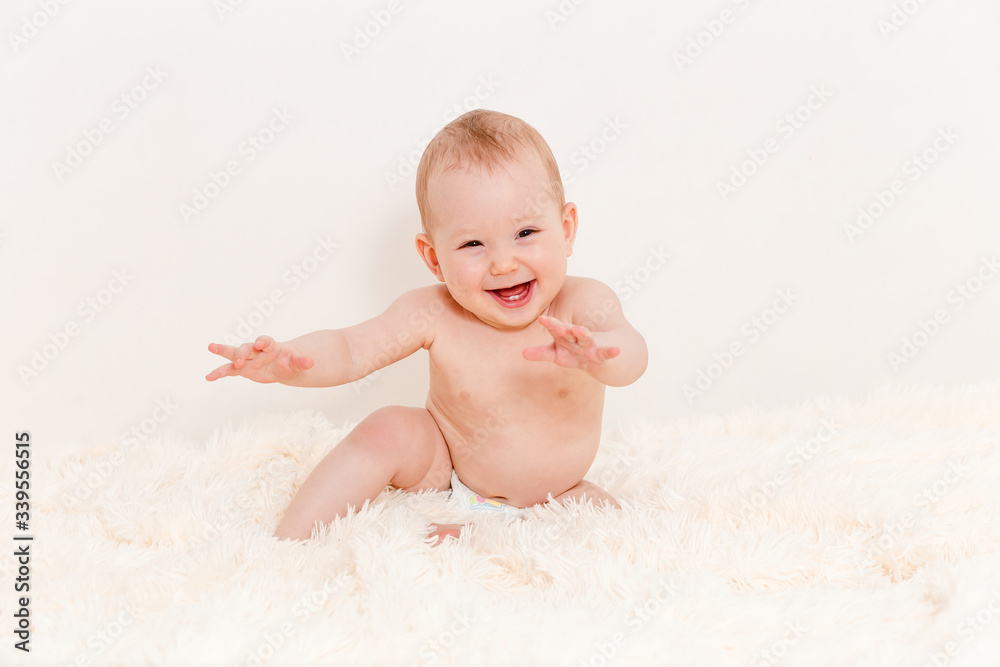 Caucasian cute baby sitting on a white fluffy blanket Caucasian cute baby sitting on a white fluffy blanket