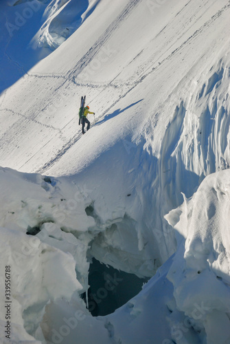 Ski mountaineer climbs a steep, dangerous glacier with large berghrunds and cracks. Alps, Mont Blanc