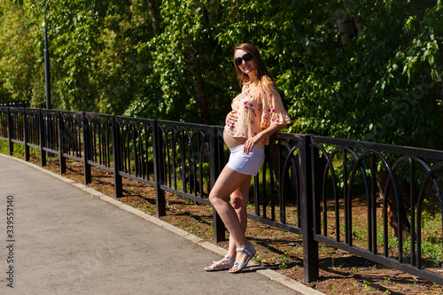 pregnant Caucasian woman in the summer in the Park in the summer. pregnancy
