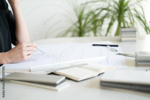 Interior designer working on drawings. Designer at work. Interior design. Architect at work. Decoration. Design project blueprints. Grey marble, stone. Decorative material. Stationery. Work from home.