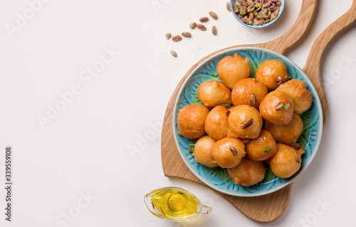 arabic sweet dessert from lokma lean products in a plate on a white background. copy space photo