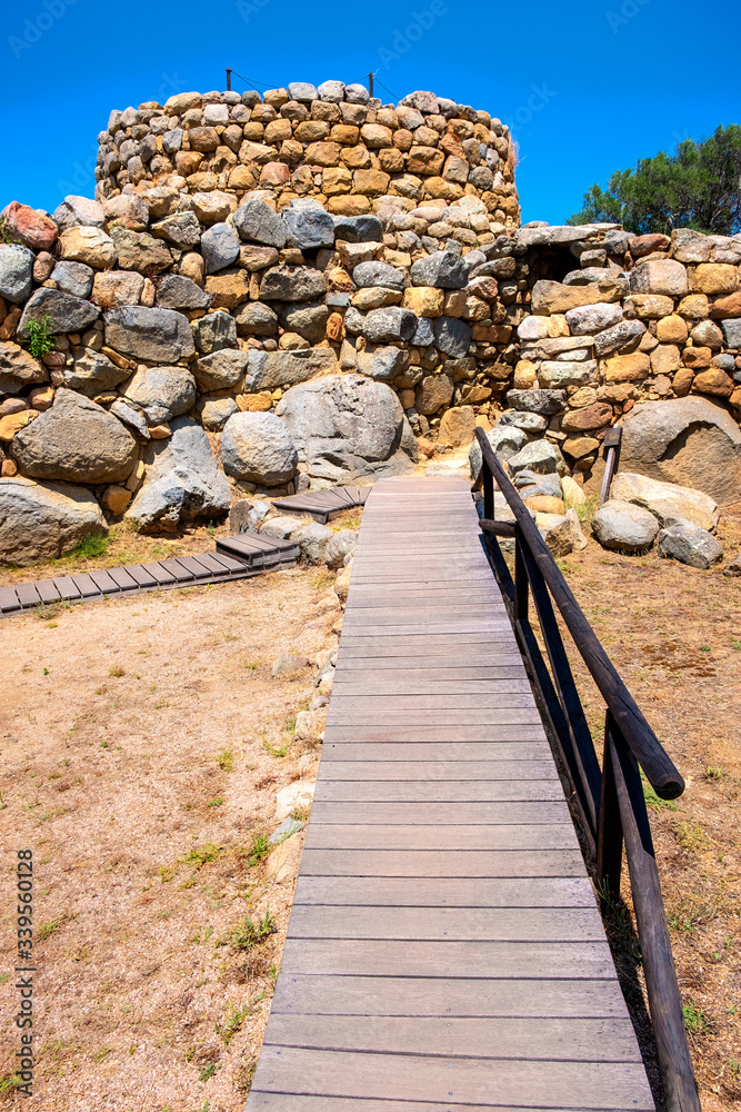 Fototapeta premium Arzachena, Sardinia, Italy - Archeological ruins of Nuragic complex La Prisgiona - Nuraghe La Prisgiona - with main entrance to stone tower of Neolithic fortress