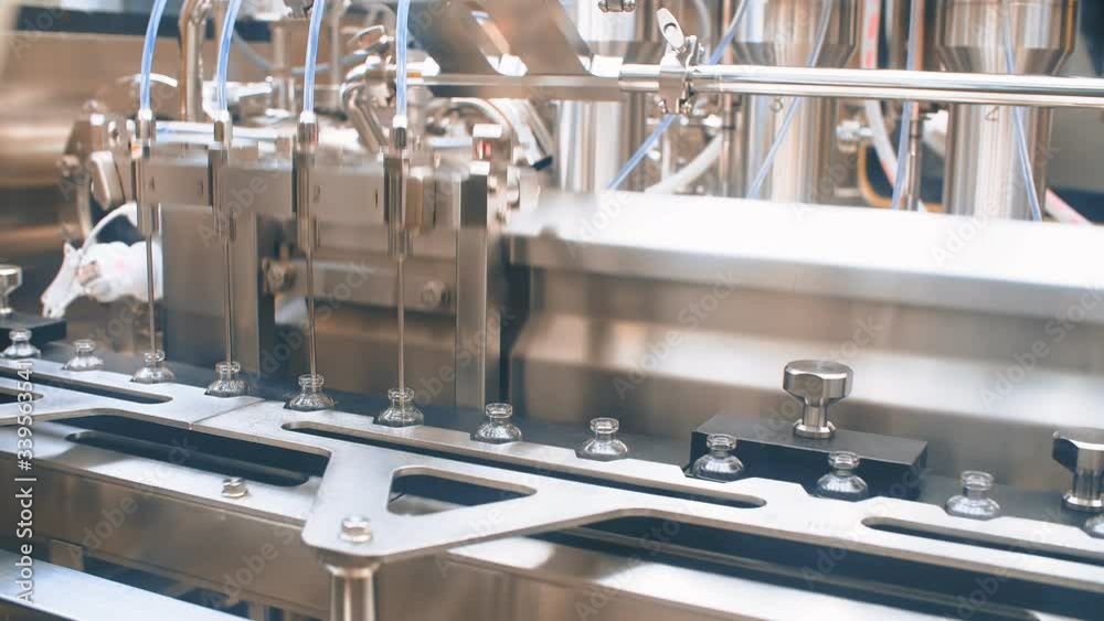 Glass bottles in production in the tray of an automatic liquid dispenser, a line for filling medicines against bacteria and viruses, antibiotics and vaccines.