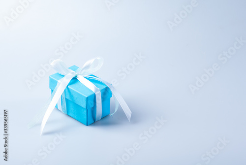 Blue gift box with white ribbon bow on white background