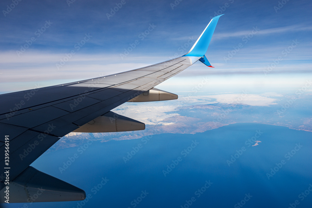 Commercial airplane flying over the island of Crete with the coastline and the Mediterranean sea, Greece, Europe