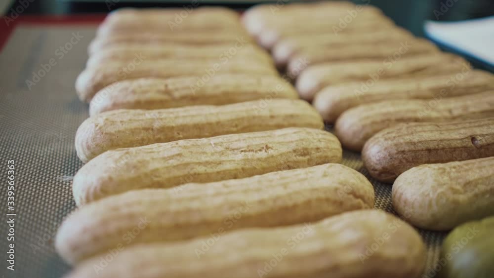 close up traditional eclair. Process of greasing unbaked eclairs with ...