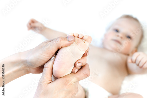 Mother massaging baby boy foot at home