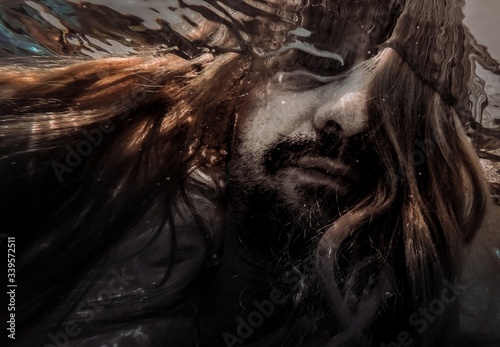 Artistic pic out of focus underwater with long hair man swimming with bubble in water, dark underwater atmosphere with nightmare human abyssal creature like mermaid with beard