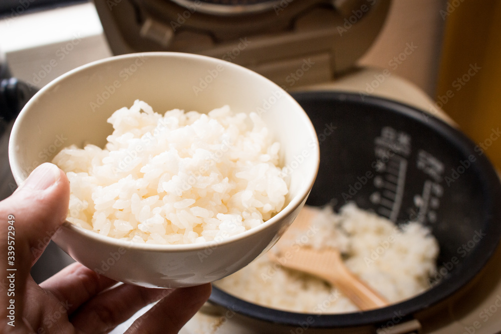 Japanese steamed rice in bowl with rice cooker. Japanese steamed rice in bowl with rice cooker.