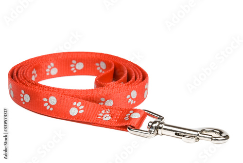 Red nylon dog lead or leash with paw print pattern isolated on white. Clipping path included.