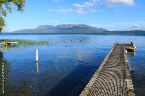The jetty at Rangiruru Bay on Lake Tarawera, New Zealand. On the other side of the lake is Mount Tarawera, a dormant volcano 