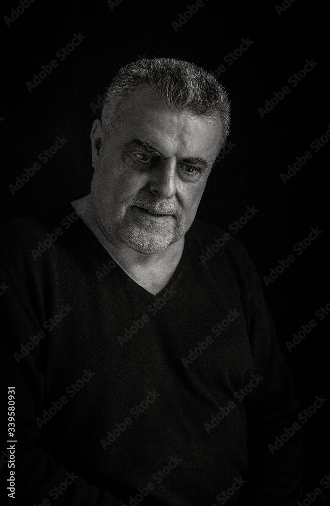 Portrait of mature man with beard on dark background