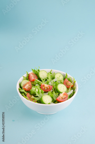 Salad bowl with frisee lettuce, baby tomato, cucumber, onion...