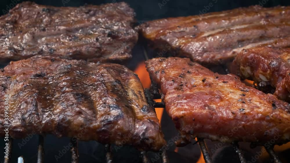 Tasty ribs cooking on barbecue grill for summer outdoor party Tasty ribs cooking on barbecue grill for summer outdoor party