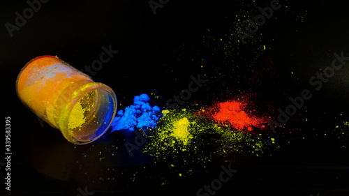 Photoluminescence chemical materials, called fluorescent. Powder glows in the dark under UV light radiation of different colors. photo