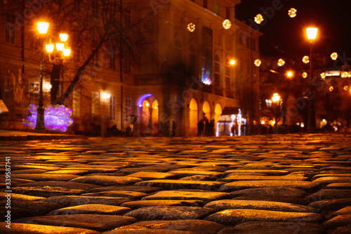 Cobble stones old european street with night city lights.