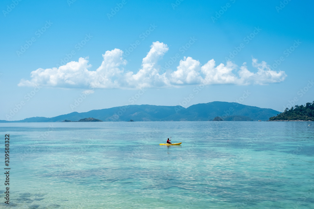Man kayaking on the beautiful tropical Ocean and blue sky background