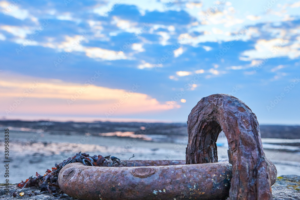 Fototapeta premium Image of rusty metal ring on pier. Shallow depth of field, selective focus. La Rocque Harbour, St Clement, Jersey CI