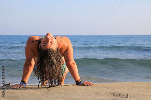 mujer joven haciendo yoga en la playa toples almería 4M0A6236-as20 photo