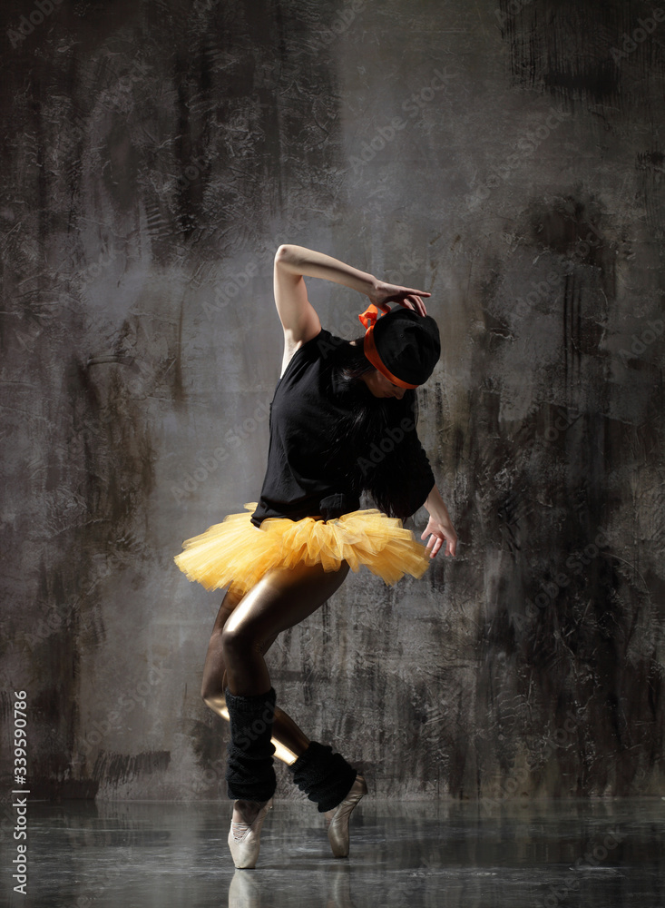 Fototapeta premium Young beautiful ballerina is posing in studio