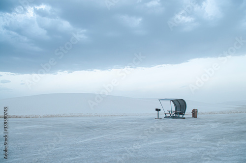 Obraz na płótnie picnic area in the middle of the white sand desert in cloudy day w salonie