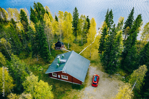Fotografia Aerial top view of log cabin or cottage with sauna in spring forest by the lake