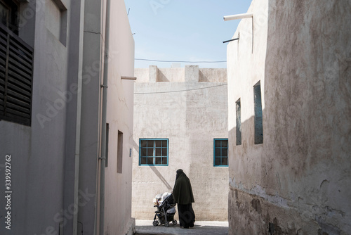 woman walking down back alley in burka