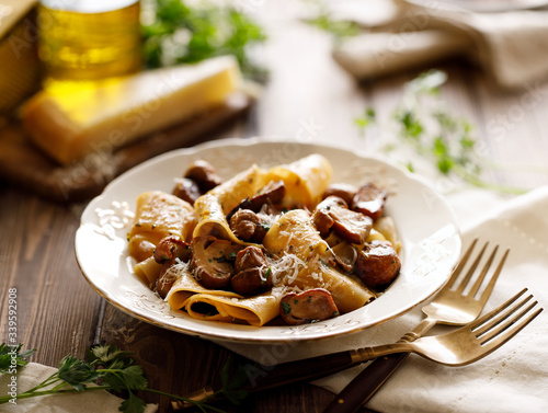 Pappardelle pasta with porcini mushrooms on a white plate, close up
