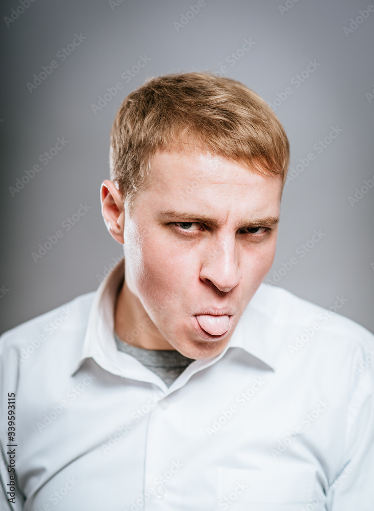 young man shows tongue