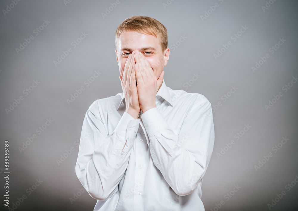 Closeup portrait of laughing excited smiling happy man covering mouth pointing at you with index finger, isolated on white background. Positive human emotion facial expression feeling, body language