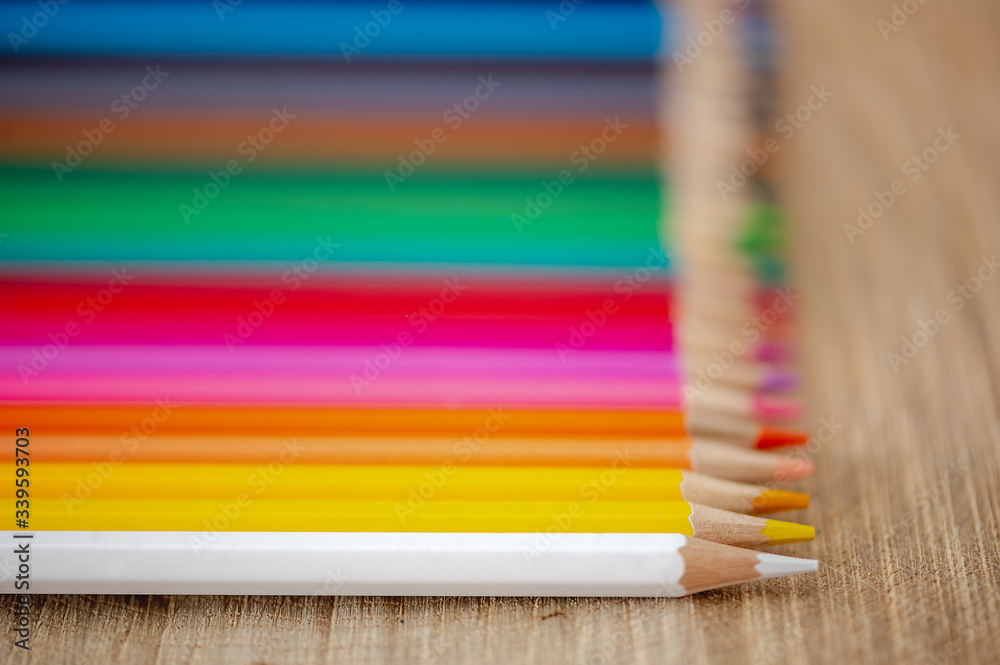 Fototapeta premium Rainbow of colored pencils on wood background