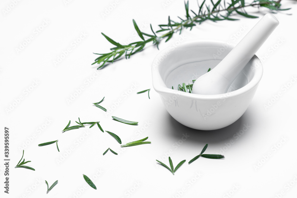 A mortar grinder drugs with herbs  - Rosemary isolated on white background.  For copy space.