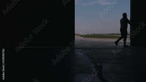 a man opens an aircraft hangar