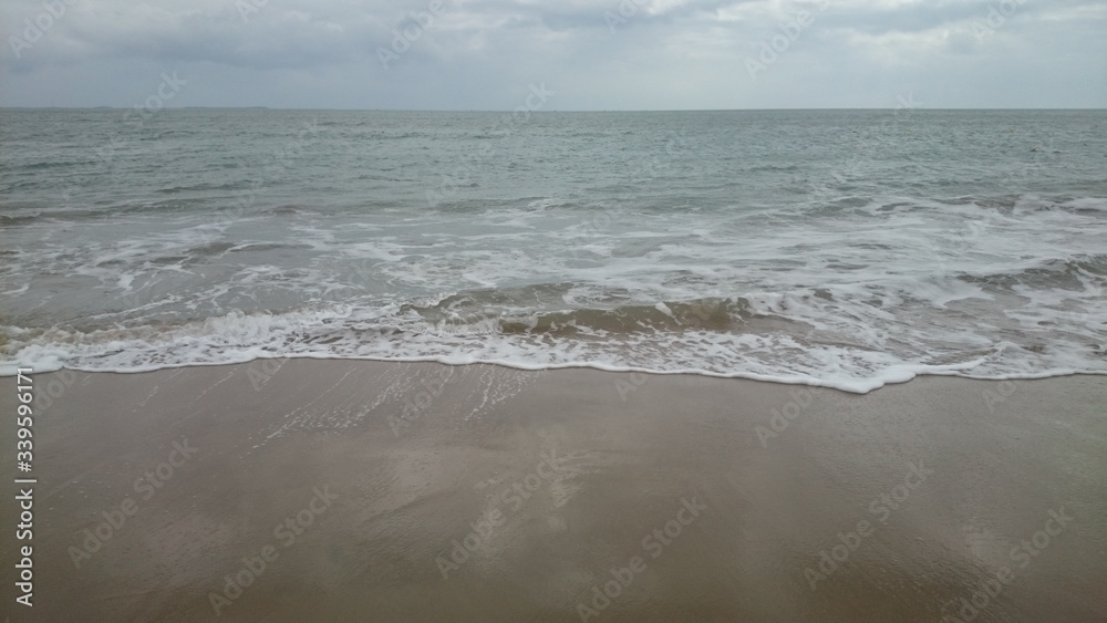 sea ??horizon, waves with foam run onto yellow sand