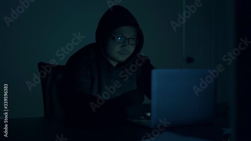 A computer programmer or hacker prints a code on a laptop keyboard to break into a secret organization system.